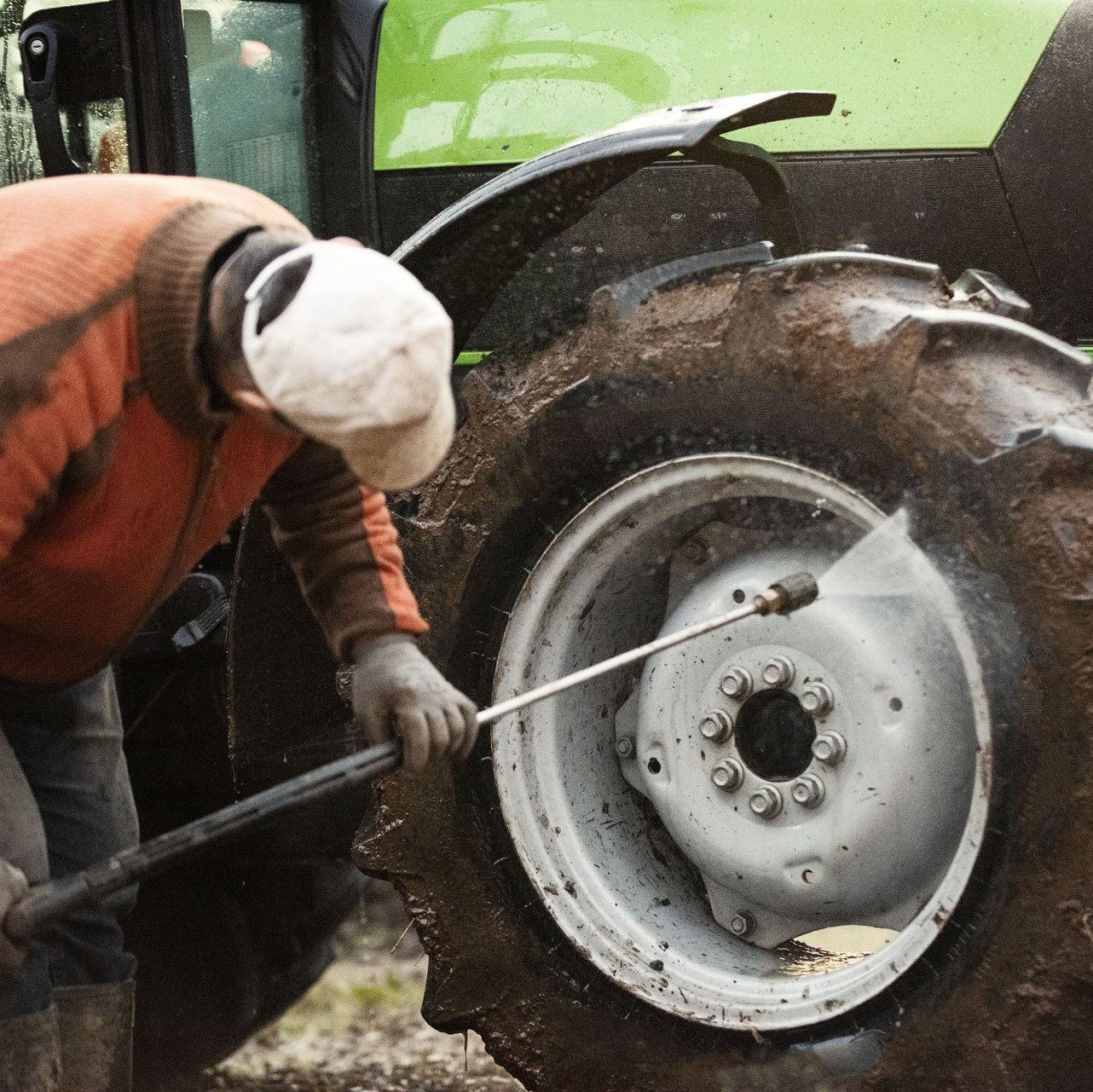 Operator pressure washing heavy equipment