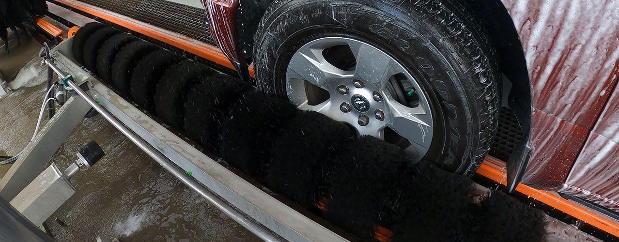 DuraScrubber professional wheel cleaning brush for car wash bays.